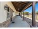 Long covered patio with ceiling fans and stone columns, offering a relaxing outdoor space with views of the backyard at 4880 E Beehive Rd, San Tan Valley, AZ 85140