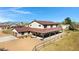 Expansive two-story home featuring a metal roof, large covered porch, and ample yard space under a bright blue sky at 4880 E Beehive Rd, San Tan Valley, AZ 85140
