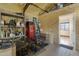 A brightly lit garage area featuring shelving, a retro fridge, and an adjacent room with window blinds at 4880 E Beehive Rd, San Tan Valley, AZ 85140