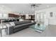 Open living room features a gray sectional sofa and glass coffee table, adjacent to a modern kitchen at 9503 W Jj Ranch Rd, Peoria, AZ 85383