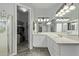 Bright bathroom featuring a double sink vanity, tile floors, and an open closet space at 3122 E Windmere Dr, Phoenix, AZ 85048