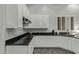 Kitchen boasts sleek dark countertops, modern white cabinets and stainless steel appliances at 3122 E Windmere Dr, Phoenix, AZ 85048