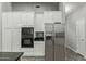 Kitchen featuring stainless steel refrigerator, built-in microwave and oven, white cabinets, and dark countertops at 3122 E Windmere Dr, Phoenix, AZ 85048