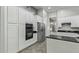 Spacious kitchen equipped with modern appliances, white cabinetry, dark countertops, and tile floors at 3122 E Windmere Dr, Phoenix, AZ 85048