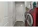 Modern laundry room with red washer/dryer, tile floors, and ample storage space at 3122 E Windmere Dr, Phoenix, AZ 85048
