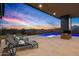 Lounge chairs overlook this relaxing outdoor space with a swimming pool and putting green at sunset at 40575 N 109Th Pl, Scottsdale, AZ 85262
