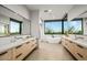 A luxurious bathroom boasts dual vanities, a soaking tub with view, and large mirrors for an open feel at 40575 N 109Th Pl, Scottsdale, AZ 85262