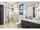 Modern bathroom featuring glass enclosed shower, black fixtures, and large mirror, combining style and function at 40575 N 109Th Pl, Scottsdale, AZ 85262