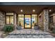 Inviting front entrance with stone accents, modern lighting, and large glass doors at 40575 N 109Th Pl, Scottsdale, AZ 85262