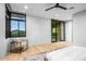 Bright main bedroom featuring hardwood floors, large windows with mountain views, and a modern ceiling fan at 40575 N 109Th Pl, Scottsdale, AZ 85262
