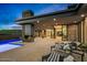 Inviting outdoor living area with stone fireplace, refreshing pool, and comfortable lounge chairs against a scenic sunset at 40575 N 109Th Pl, Scottsdale, AZ 85262