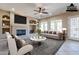 Bright living room with a fireplace, ceiling fan, and large windows allowing natural light to fill the room at 17724 W Ocotillo Ave, Goodyear, AZ 85338