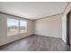 Bedroom with modern wood-look floors and double window with desert view at 52089 W Organ Pipe Rd, Maricopa, AZ 85139