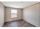 Bedroom featuring modern wood-look floors and natural light with desert view at 52089 W Organ Pipe Rd, Maricopa, AZ 85139