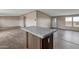 Open-concept living room featuring a kitchen island with marbled countertop at 52089 W Organ Pipe Rd, Maricopa, AZ 85139