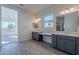 Double vanity bathroom with grey cabinets and quartz countertops at 16405 W Desert Mirage Dr, Surprise, AZ 85388