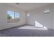 Spacious bedroom with a large window and carpeted floor at 16405 W Desert Mirage Dr, Surprise, AZ 85388