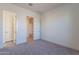 Bright bedroom with carpet flooring and access to a bathroom and hallway at 16405 W Desert Mirage Dr, Surprise, AZ 85388