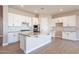 Modern kitchen with white cabinets, quartz countertops, and stainless steel appliances at 16430 W Desert Mirage Dr, Surprise, AZ 85388