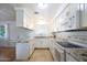 L-shaped kitchen with granite countertops and white cabinets at 4833 N 69Th Dr, Phoenix, AZ 85033