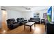 Living room with hardwood floors and black leather furniture at 4833 N 69Th Dr, Phoenix, AZ 85033