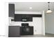 Kitchen featuring modern black appliances, black cabinets, and white countertops at 15463 W Mescal St, Surprise, AZ 85379