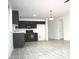 Open-concept kitchen with black appliances, cabinets and light-colored flooring at 15463 W Mescal St, Surprise, AZ 85379