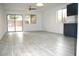 Inviting living room featuring a sliding door to backyard, light-colored flooring and dark cabinets at 15463 W Mescal St, Surprise, AZ 85379