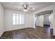 Bright bedroom with wood-look floors, ceiling fan and barn doors at 7088 W Redbird Rd, Peoria, AZ 85383