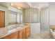Luxurious bathroom featuring a double vanity, glass block wall, and marble countertops at 9853 E Sundance Trl, Scottsdale, AZ 85262