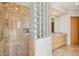 Luxurious bathroom featuring a glass block wall, marble tile, and a modern walk-in shower at 9853 E Sundance Trl, Scottsdale, AZ 85262