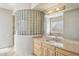 Bright bathroom featuring a unique glass block wall, marble countertops, and modern fixtures at 9853 E Sundance Trl, Scottsdale, AZ 85262