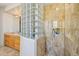 Modern bathroom featuring marble tile, a glass block accent wall, and a walk-in shower at 9853 E Sundance Trl, Scottsdale, AZ 85262