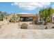 Exterior of home featuring desert landscaping, stone accents, and a circular, modern design at 9853 E Sundance Trl, Scottsdale, AZ 85262