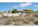 Exterior of a modern desert home with desert landscaping in front and partial view of a pool at 9853 E Sundance Trl, Scottsdale, AZ 85262