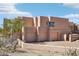 Exterior of modern desert home featuring a three-car garage and desert landscaping at 9853 E Sundance Trl, Scottsdale, AZ 85262