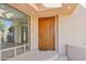 Front entrance featuring a solid wood door, large window, and desert landscape at 9853 E Sundance Trl, Scottsdale, AZ 85262