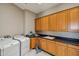 Well-equipped laundry room with washer, dryer, sink, and ample cabinet space for storage at 9853 E Sundance Trl, Scottsdale, AZ 85262