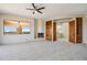 Inviting living room featuring a stone fireplace, custom built-ins, and backyard views at 9853 E Sundance Trl, Scottsdale, AZ 85262