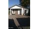 A garage sits on a concrete slab with doors covered with boards and a barred window with a bench at 1006 S 3Rd Ave, Phoenix, AZ 85003