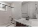 This bright bathroom features a shower and tub combination and a single sink vanity with ample lighting at 12687 W Caraveo Pl, Peoria, AZ 85383