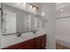 Bathroom featuring a double vanity with granite countertop and a shower at 12687 W Caraveo Pl, Peoria, AZ 85383