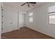 A brightly lit bedroom featuring neutral walls, brown carpet, and natural light at 12687 W Caraveo Pl, Peoria, AZ 85383