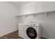 This laundry room has laminate floors, a shelf, and a washing machine and dryer at 12687 W Caraveo Pl, Peoria, AZ 85383