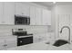 Close-up of a stylish kitchen with quartz countertops, stainless steel appliances, and bright white cabinets at 18168 W Pima St, Goodyear, AZ 85338