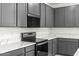 Gourmet kitchen features modern appliances, white countertops, lots of storage and gray colored cabinets at 18174 W Pima St, Goodyear, AZ 85338