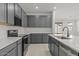 Modern kitchen boasts grey cabinets, stainless appliances, a stylish faucet, and an island at 18174 W Pima St, Goodyear, AZ 85338