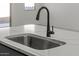 Kitchen boasts a stainless steel sink, modern faucet and white countertops at 18174 W Pima St, Goodyear, AZ 85338