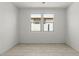 An empty room featuring tile flooring, white walls, and natural light at 18174 W Pima St, Goodyear, AZ 85338