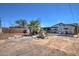 Wide backyard with dirt and gravel, featuring various trees and a shed at 2124 W Maricopa St, Phoenix, AZ 85009